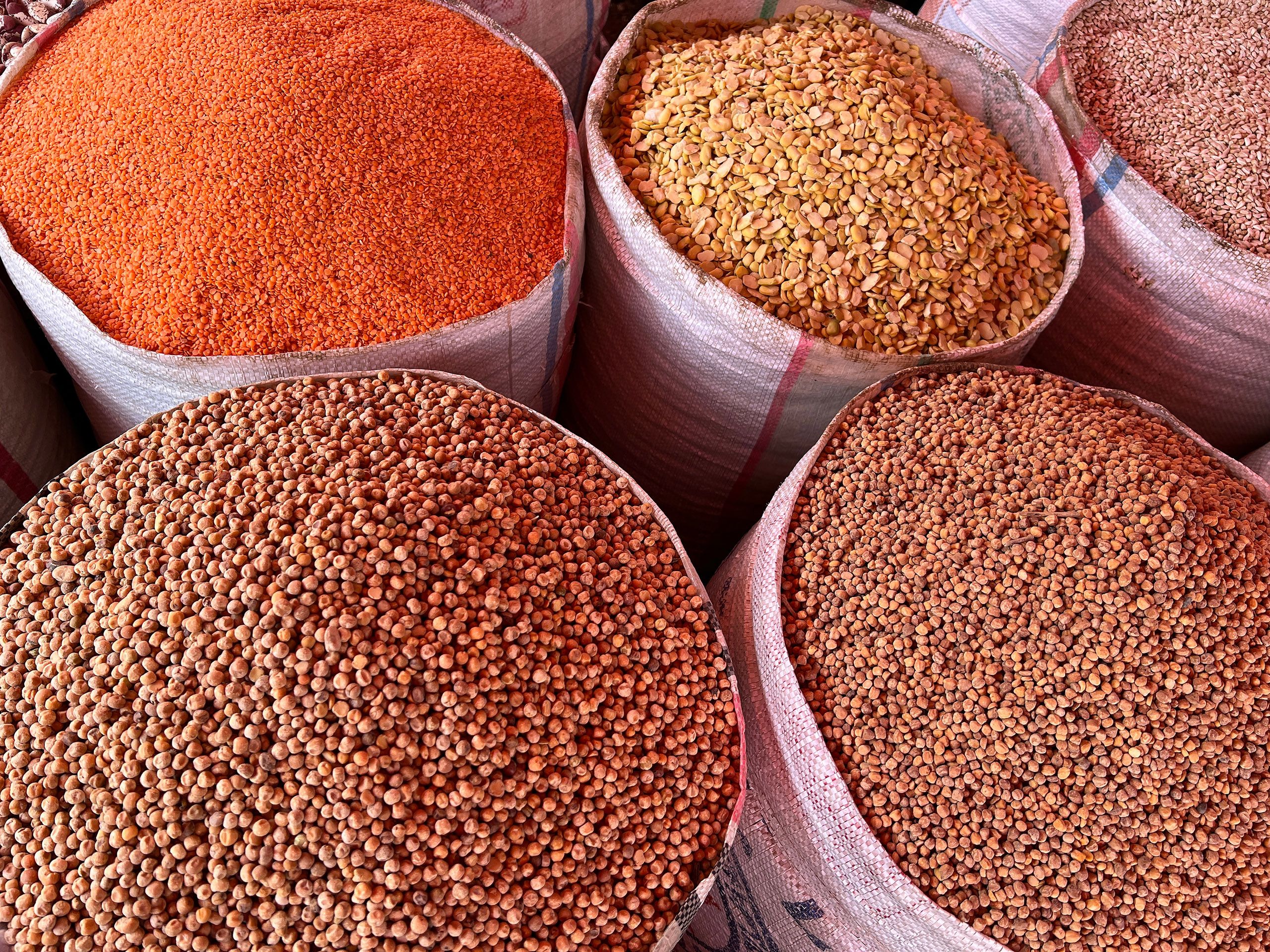 Baskets of different dried beans fill the image.