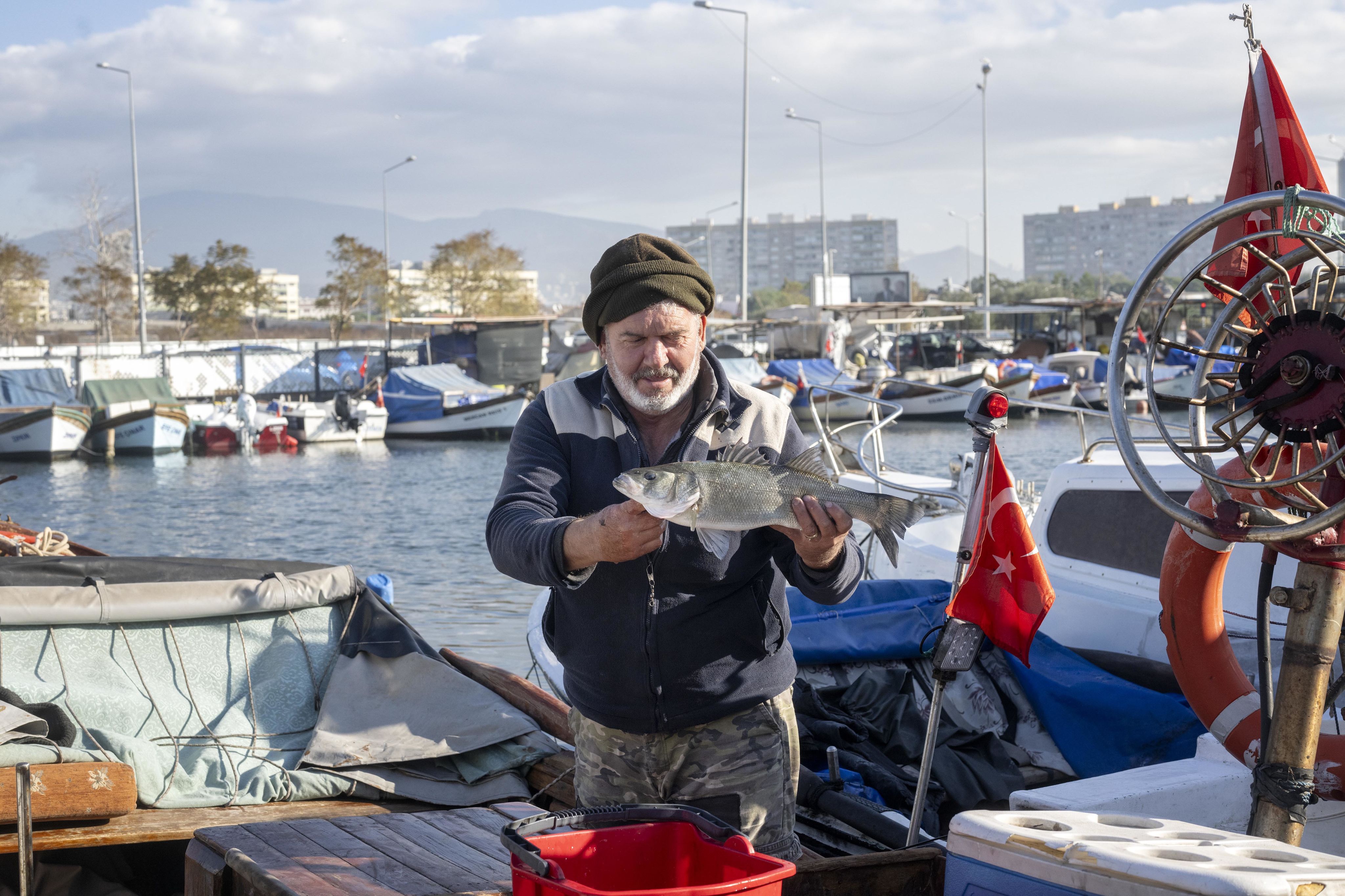 Un pêcheur brandit sa prise du jour dans la baie d'Izmir.