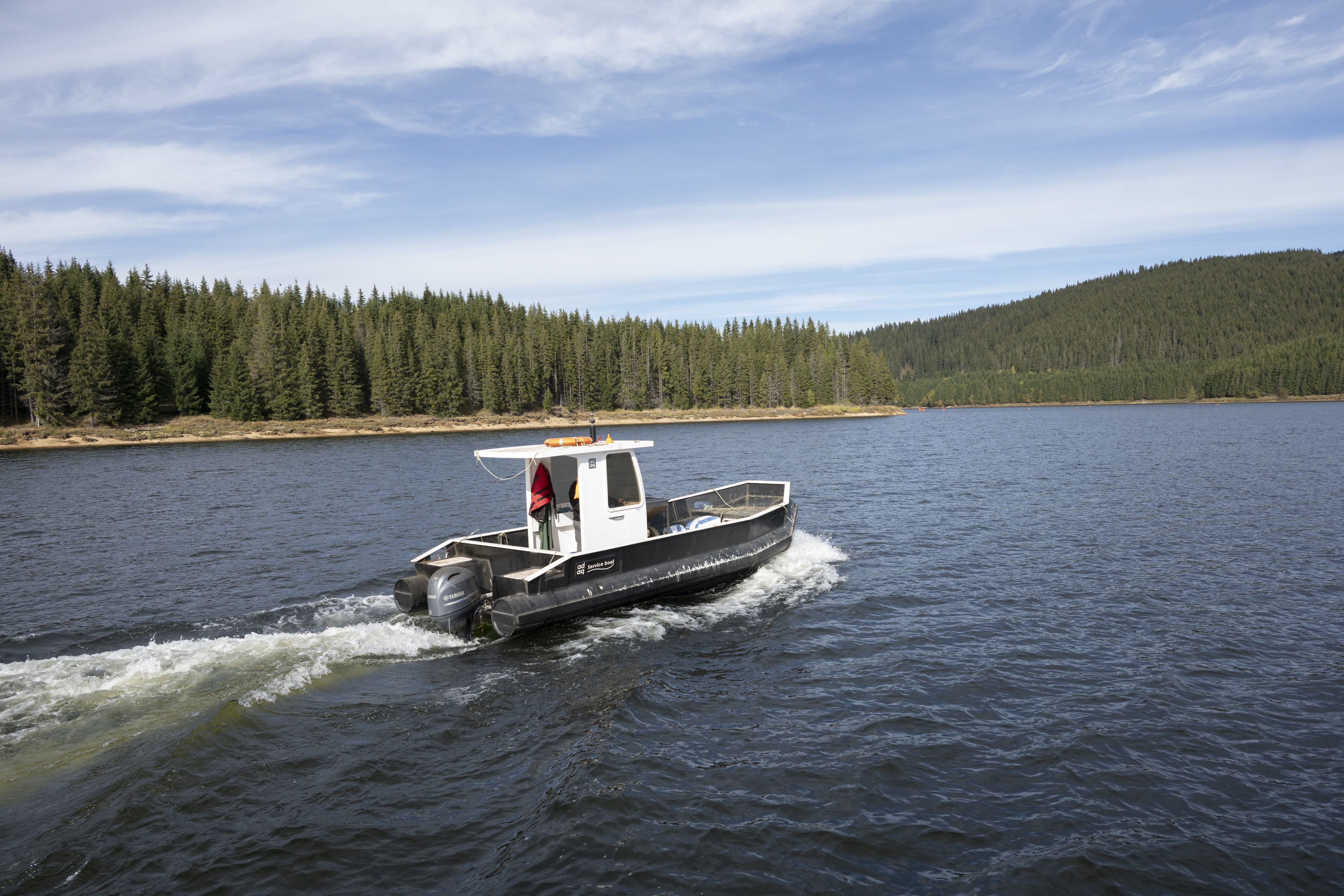 A worker heads out to the fishery cages in Oasa Lake.