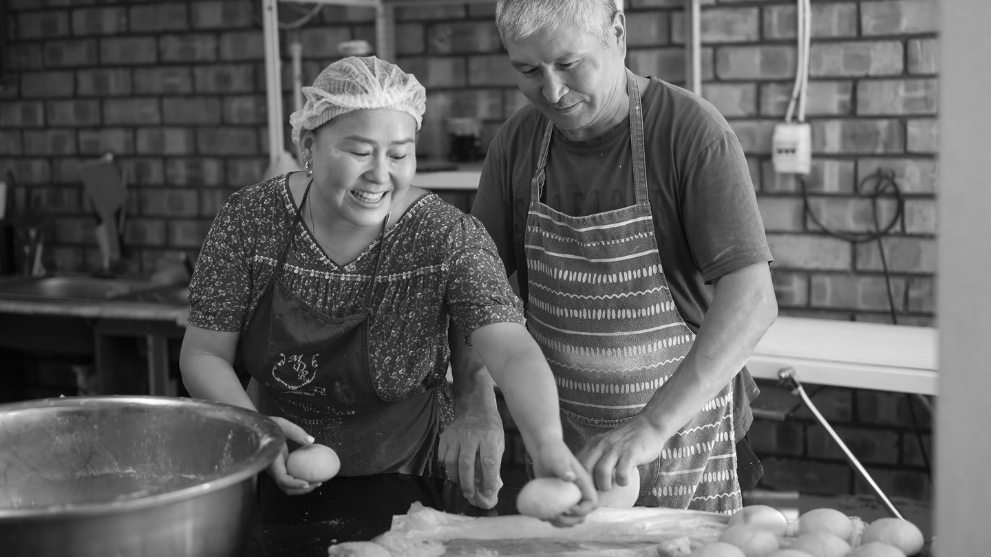 Nazgul Attokurova and her husband making pastries. 